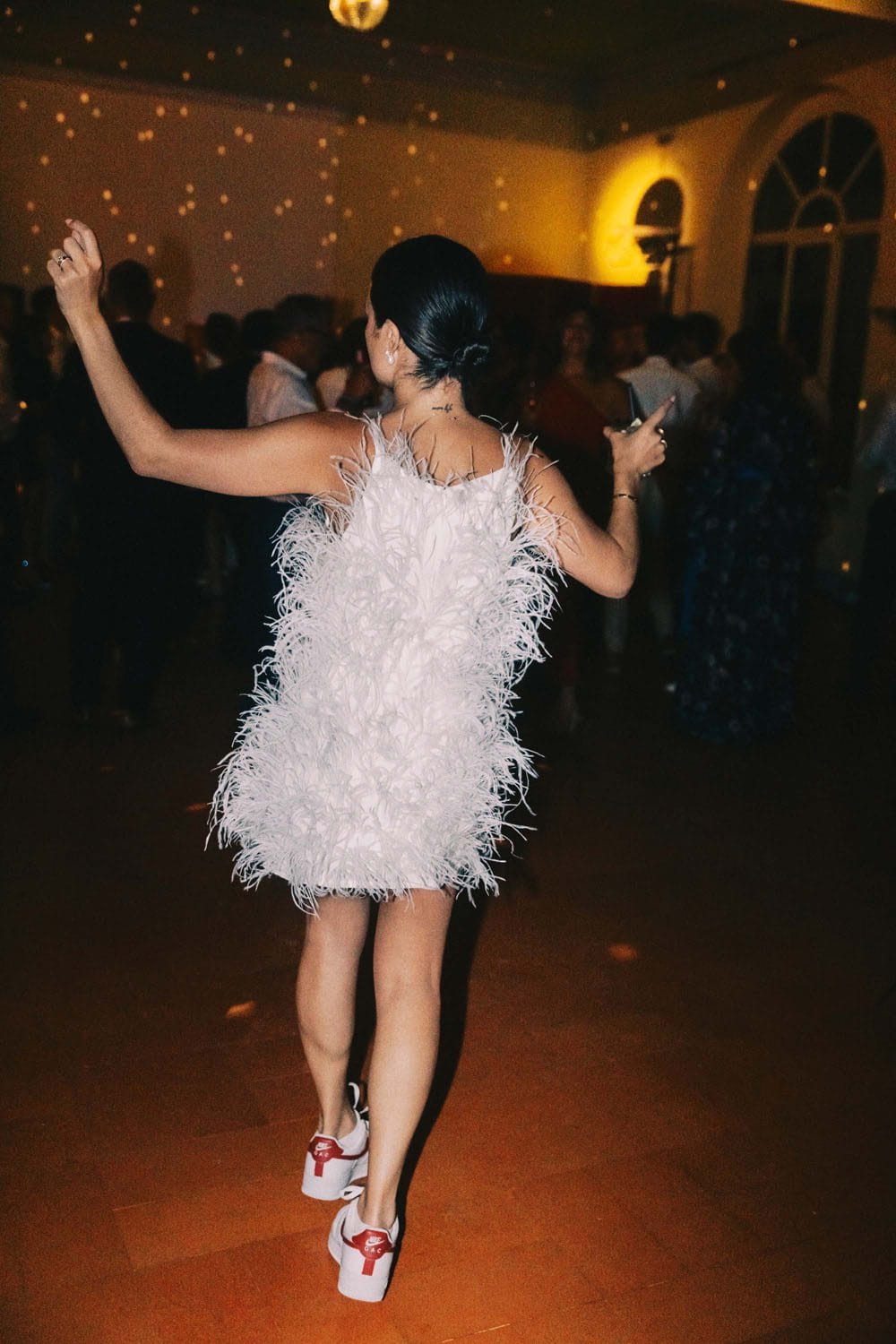 Mariée en robe pour mariage à plumes avec baskets lors d'un mariage en Italie